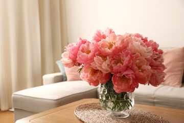 Beautiful pink peonies in vase on table at home, space for text. Interior design