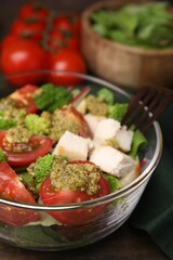 Delicious salad with pesto sauce and fork on table, closeup