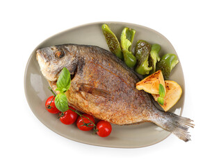 Delicious roasted dorado fish, vegetables, and lemon isolated on white, top view