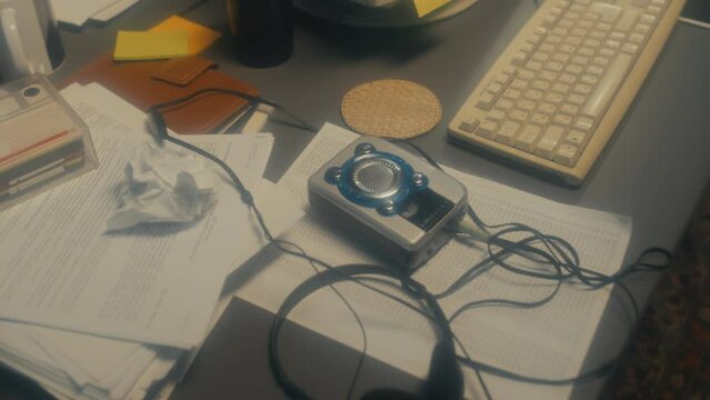 High angle view shot of personal stereo, headphones, papers and computer keyboard on table, 90s aesthetics
