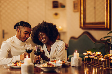 African american couple having romantic date at home and using a smartphone