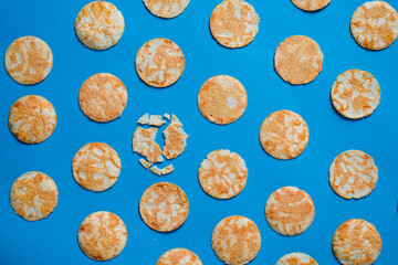 Fototapeta na wymiar Round rice chips on a blue paper background. 