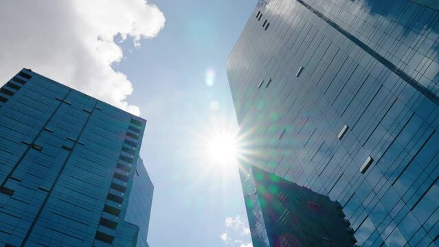 Time lapse of clouds reflecting into the glass of a large office building