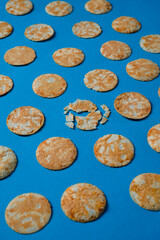 Round rice chips on a blue paper background. 