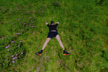 Man lying on grass with his arms and legs spread