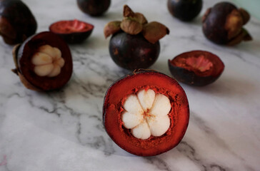 Fresh and delicious mangosteen vesicles in white marble background                                