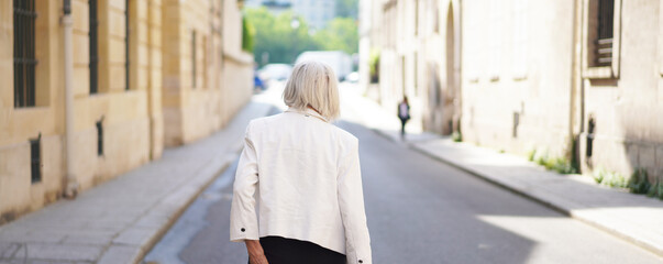 Senior Woman Walking through the Streets of Paris - obrazy, fototapety, plakaty