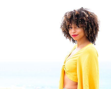 A portrait of a girl with afro hair in a yellow tropical style blouse