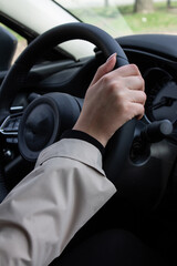 hands of a young girl on a car steering wheel