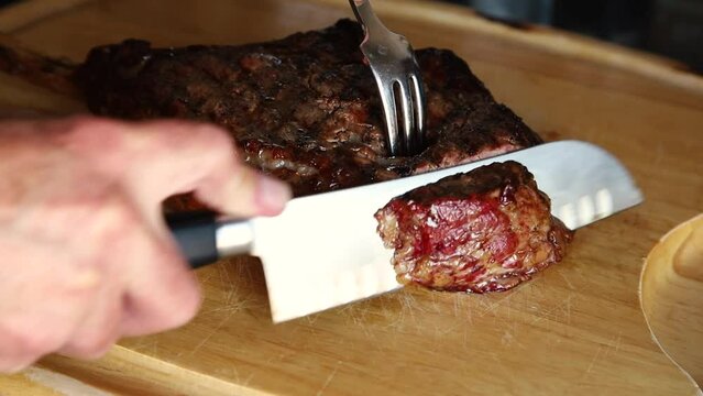 Chef slices tomahawk ribeye steak