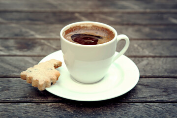Top view on small cap of strong coffee espresso with cookie on wooden table. High quality photo
