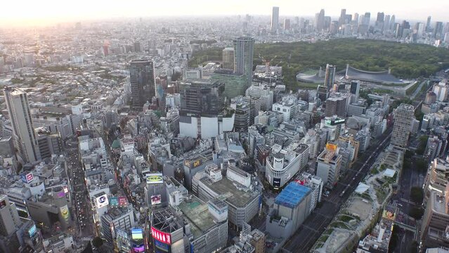 SHIBUYA, TOKYO, JAPAN - MAY 2023 : Aerial high angle view of SHIBUYA CROSSING in sunset time. Japanese urban city life and metropolis concept 4K video. Long time lapse shot, dusk to night.