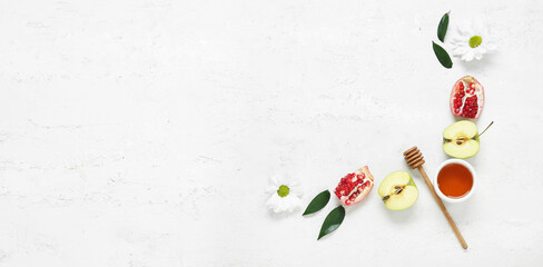 Ripe pomegranates, apples, flowers and honey on white background with space for text. Rosh Hashanah (Jewish New Year) celebration