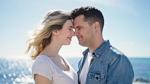 Man and woman couple smiling confident kissing on head at seaside