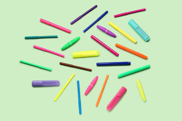 Composition with colorful markers on green background