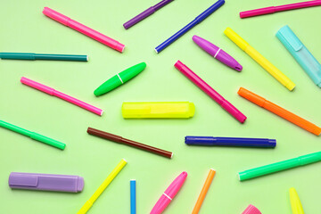 Composition with colorful markers on green background