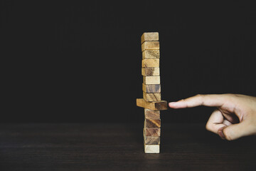 Close-up hand prevent wooden block not falling domino concepts of financial risk management and...