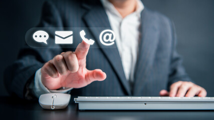 Businessman hand touching white virtual reality assistant interface mobile computer keyboard and mouse email mail phone web address and support chat icon. Customer care service representation concept.