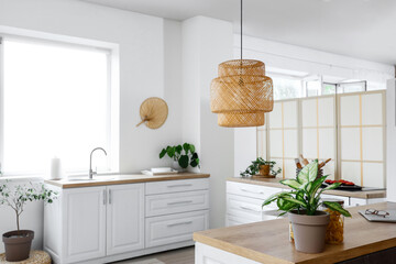 Interior of light kitchen with white counters near window - Powered by Adobe