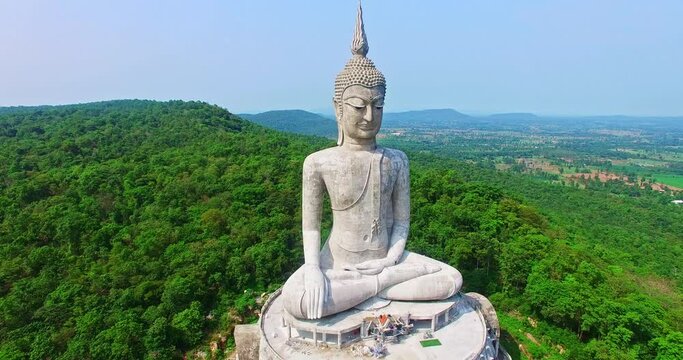 aerial view Big white buddha statue on mountain for thai people travel visit and respect .praying at Wat Roi Phra Phutthabat Phu Manorom on May 15, 2017 in Mukdahan, Thailand.. Kong river background.