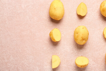 Raw baby potatoes and slices on pink background