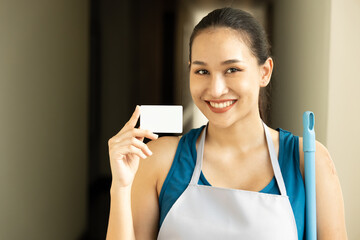Empowering the Working Class. Young happy smiling Asian Woman Cleaner Holding Credit Card, Shining...