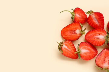 Halves of fresh strawberries on beige background