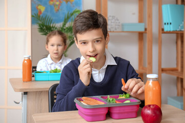 Little boy eating lunch in classroom