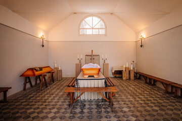 An open wooden coffin is placed in the chapel