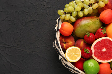 Bowl with different fresh fruits on black background