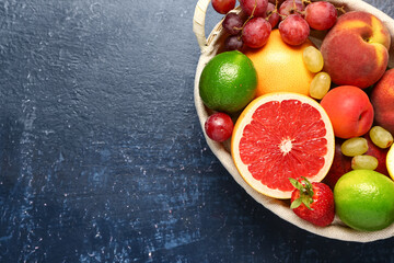 Wicker basket with different fresh fruits on blue background