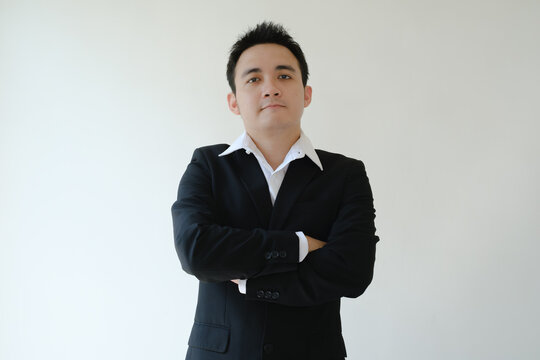 Young Asian businessman standing and looking in front of the camera. Isolated white background.