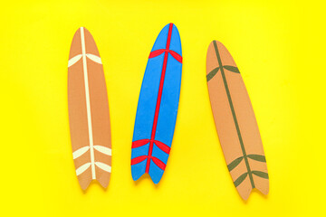 Mini different colorful surfboards on yellow background