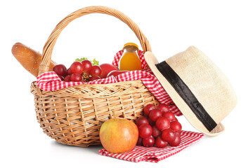 Wicker basket with tasty food for picnic, juice and hat on white background