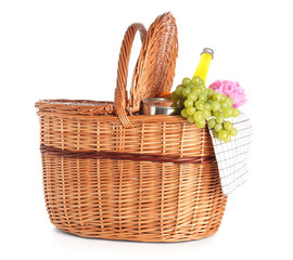 Wicker basket with tasty food for picnic, juice and peony flower on white background