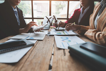 Businesswoman teamwork discussing brainstorming and calculating with calculator on evaluation data in conference room Focus on business growth and point out financial accounting charts.