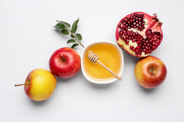 Composition with bowl of sweet honey, ripe apples and pomegranate isolated on white background. Rosh hashanah (Jewish New Year) celebration