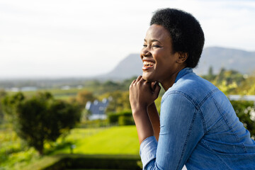 Profile of happy african american woman staying on sunny terrace with copy space