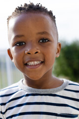 Portrait of happy african american boy on sunny terrace