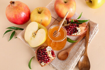 Jar of honey, pomegranate and apples for Rosh Hashanah celebration (Jewish New Year) on beige background