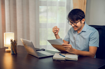Asian businessman leaves celebrating success looking at computer Successful businessman victory win with documents and computer. Good news. Good news. Success. Initial bet win.