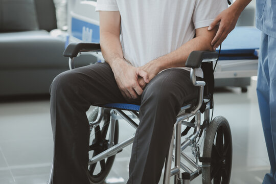 Male patient sitting in wheelchair undergoing a medical examination with specialist physician, treating injuries Getting medical treatment from specialist doctor can get the right and proper treatment
