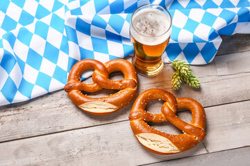 Flag of Bavaria, mug with beer and pretzels on grey wooden background