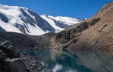 Obraz premium small turquoise lake and hight snowy peaks in the Altai mountains, Aktru at summer day, blue sky