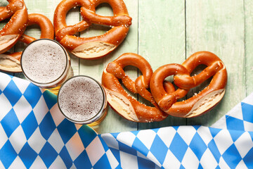 Flag of Bavaria, mugs with beer and pretzels on green wooden background