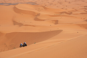 Fototapeta na wymiar Motorbikers driving off-road in the Erg Chebbi desert near Merzouga