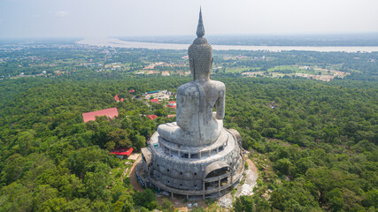 Obraz premium .aerial view Big white buddha statue on mountain for thai people travel visit and respect .praying at Wat Roi Phra Phutthabat Phu Manorom on May 15, 2017 in Mukdahan, Thailand. Kong river background..