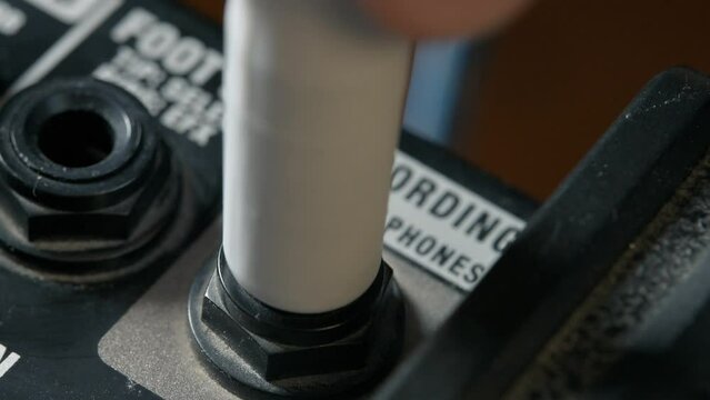Man plug in jack and tuning volume knob on guitar amplifier. 4k video footage UHD 3840x2160