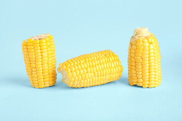 Cut fresh corn cobs on blue background