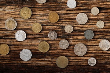 Old foreign currency coins on wood